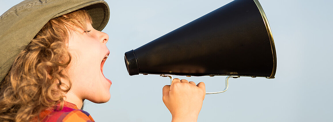 Young boy yelling into a megaphone