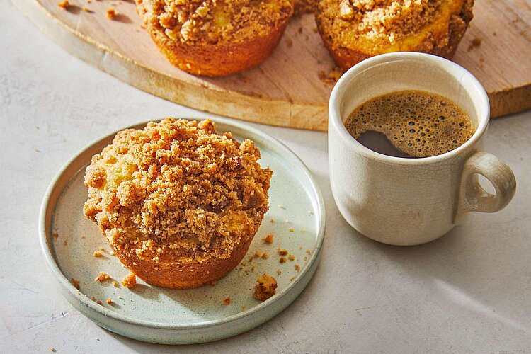 Graphic including a muffin on a plate and a white cup of coffee