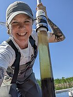 Christine Cornish (fellow) on the water holding a fresh sediment core
